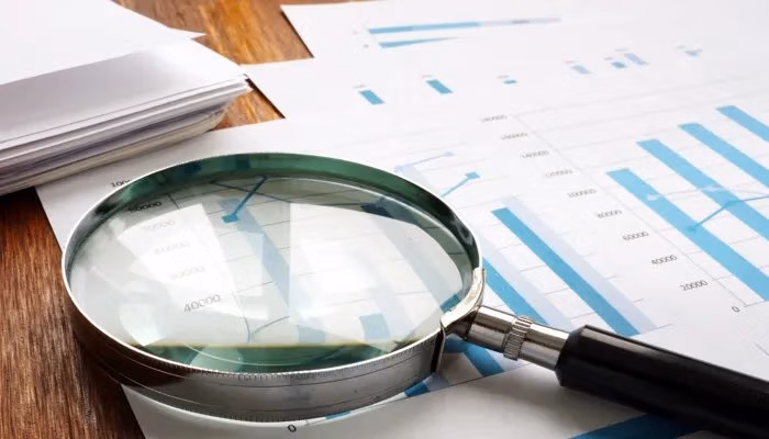 Internal audit: magnifying glass used to examine audit documents