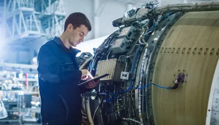Predictive maintenance technician inspecting aircraft engine